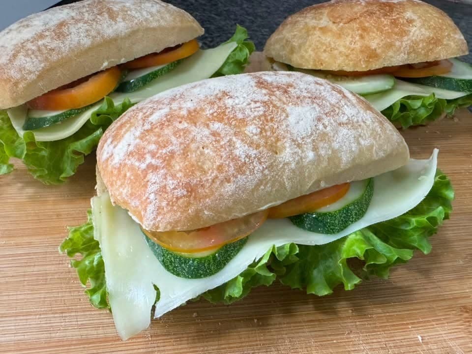 Fresh ciabatta sandwiches with cheese, cucumber, tomato, and lettuce