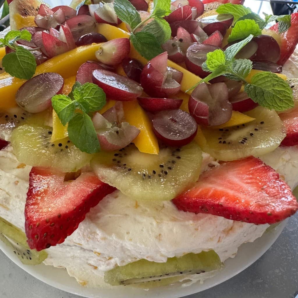 Fresh fruit pavlova with strawberries, kiwi, mango, and grapes