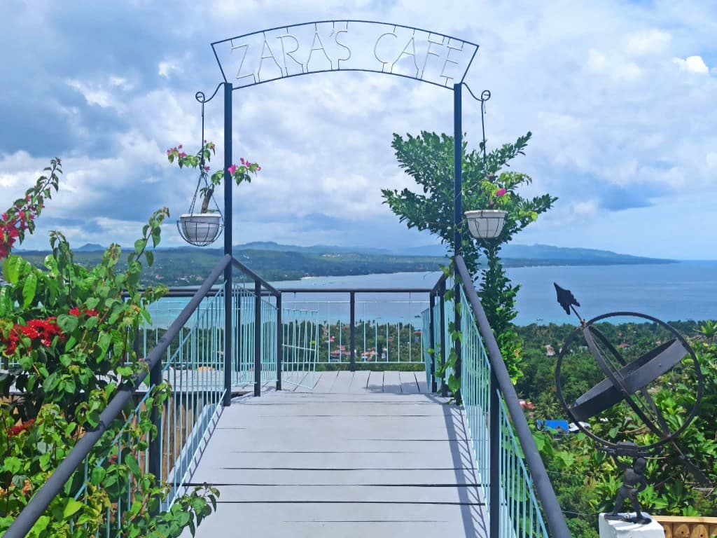 Zara's Cafe entrance archway overlooking the sea and hills in Dauis, Bohol